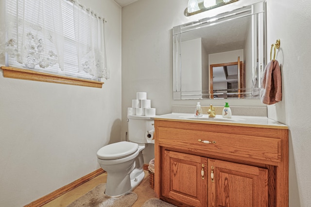 bathroom with tile patterned flooring, vanity, and toilet