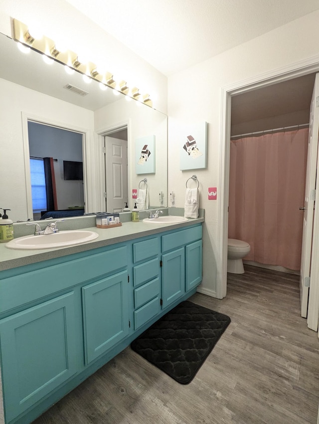 bathroom featuring hardwood / wood-style floors, vanity, and toilet