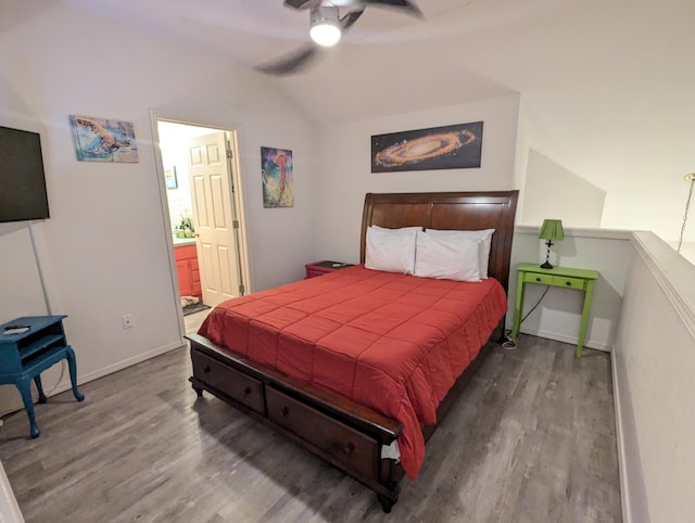 bedroom with ceiling fan, dark hardwood / wood-style floors, lofted ceiling, and ensuite bath