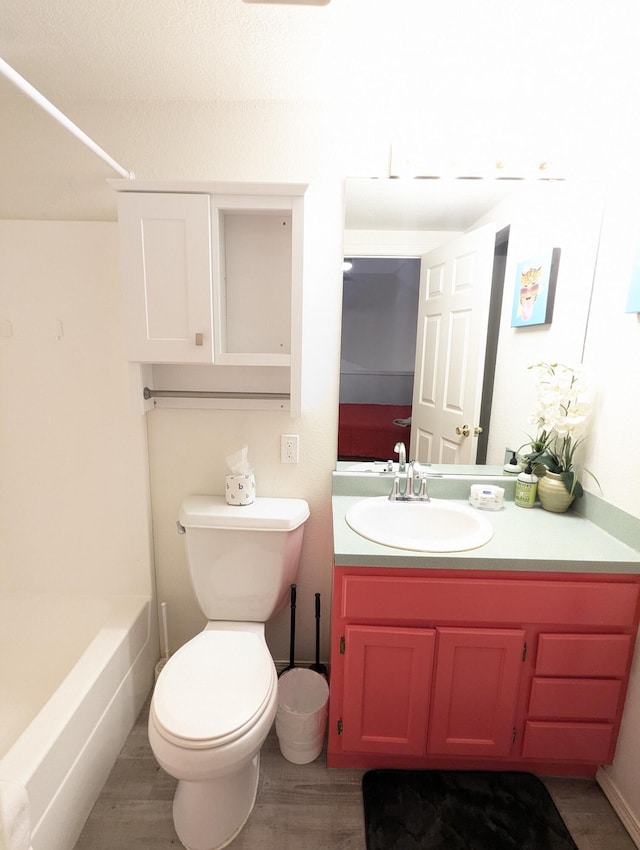 bathroom with hardwood / wood-style flooring, vanity, and toilet