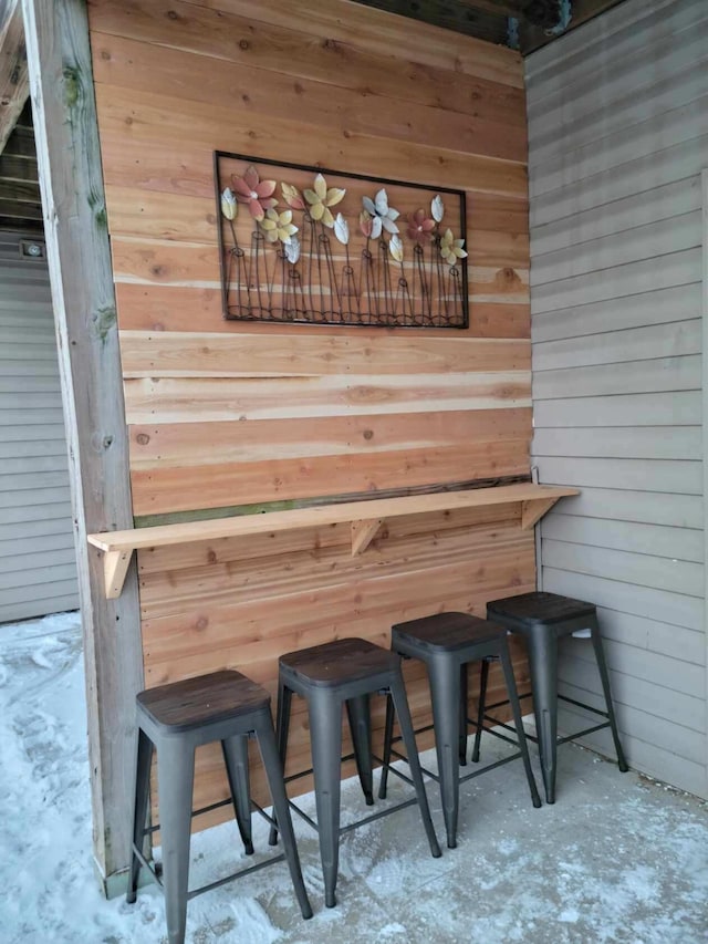 bar featuring wood walls and concrete floors