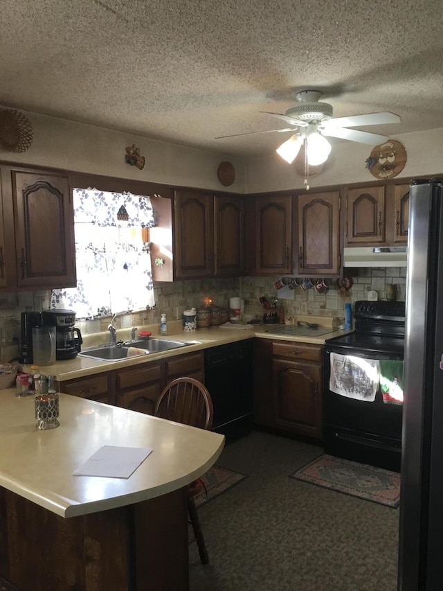 kitchen featuring ceiling fan, sink, a kitchen breakfast bar, kitchen peninsula, and black appliances