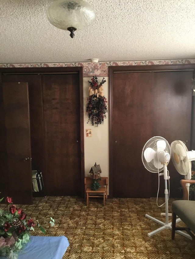 carpeted entrance foyer featuring a textured ceiling