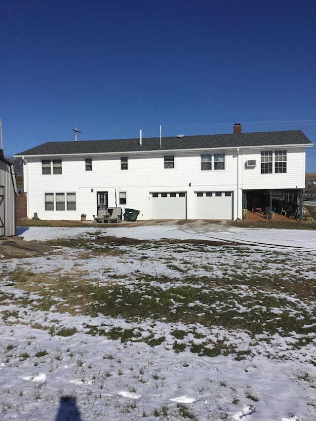 snow covered house with a garage