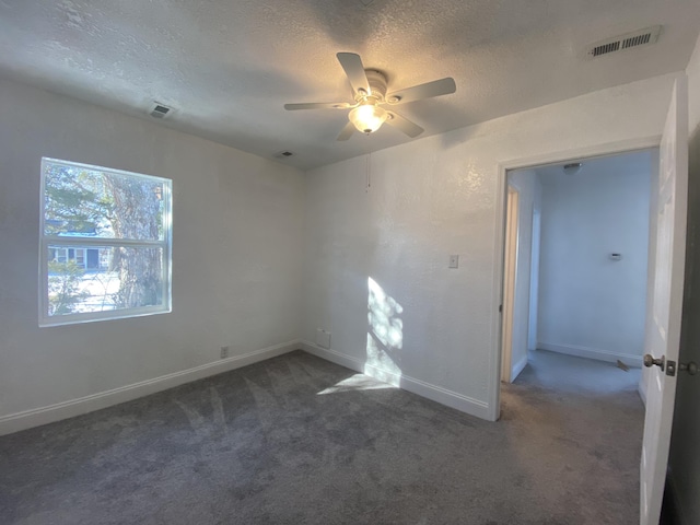 carpeted empty room with a textured ceiling and ceiling fan