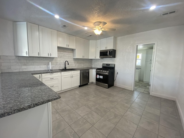 kitchen featuring appliances with stainless steel finishes, backsplash, ceiling fan, sink, and white cabinets