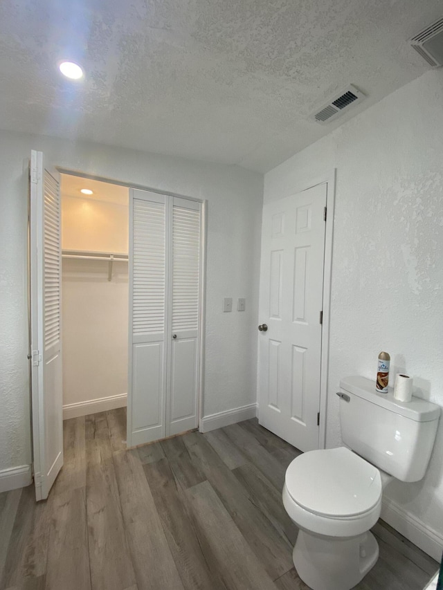 bathroom featuring hardwood / wood-style floors and toilet