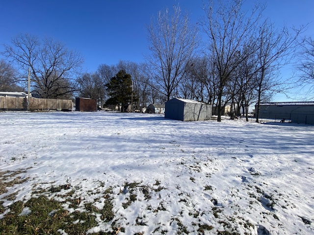 yard covered in snow featuring a storage unit