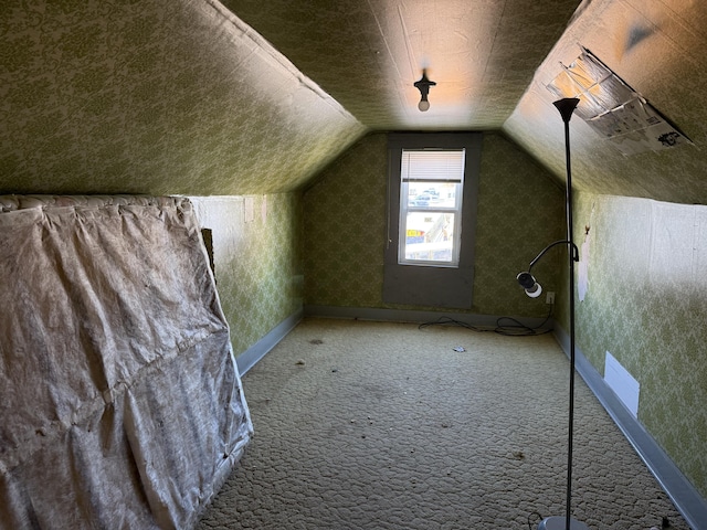 bonus room with carpet flooring and vaulted ceiling