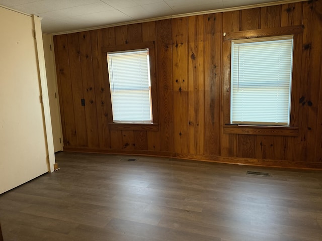 spare room with wood walls, ornamental molding, and hardwood / wood-style flooring