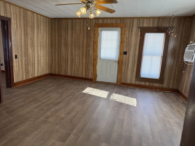 interior space with dark hardwood / wood-style flooring, an AC wall unit, and ceiling fan