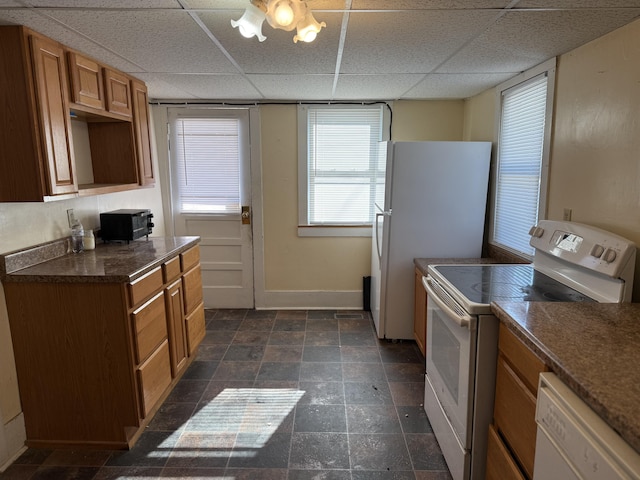 kitchen with a paneled ceiling and white appliances