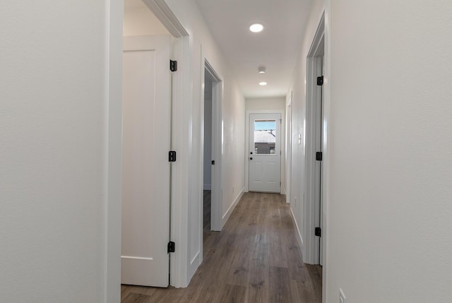 hall with baseboards, wood finished floors, and recessed lighting