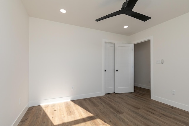 unfurnished bedroom featuring ceiling fan, dark hardwood / wood-style flooring, and a closet