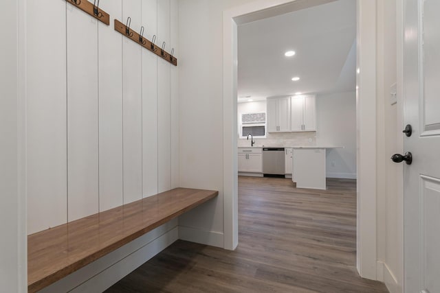 mudroom with wood finished floors, recessed lighting, a sink, and baseboards