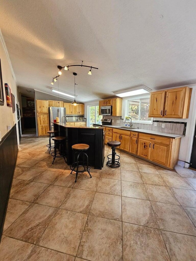 kitchen with backsplash, a breakfast bar area, a center island, decorative light fixtures, and lofted ceiling