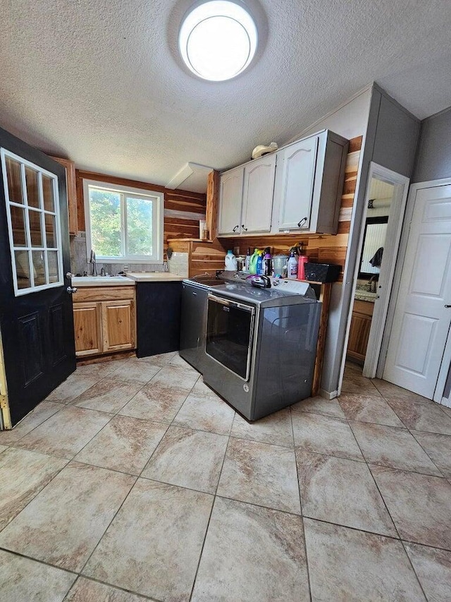 kitchen featuring washer / dryer, a textured ceiling, and sink