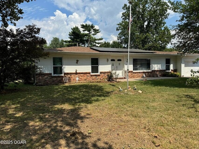 rear view of house featuring solar panels and a yard