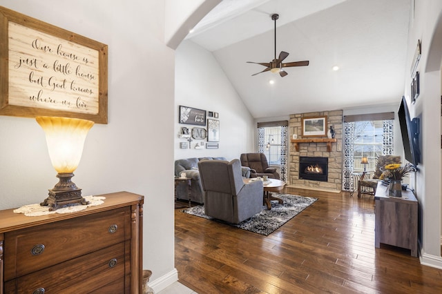 living room featuring a stone fireplace, a wealth of natural light, lofted ceiling, and ceiling fan