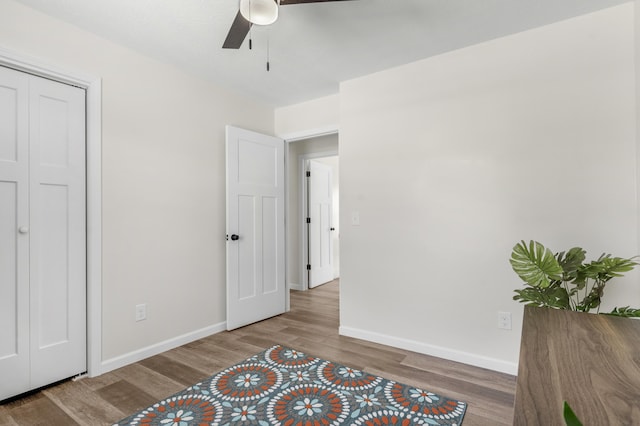 bedroom featuring ceiling fan, a closet, and wood-type flooring