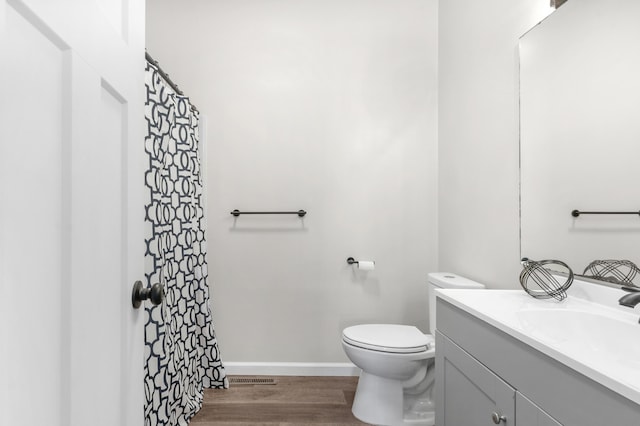 bathroom featuring vanity, wood-type flooring, and toilet