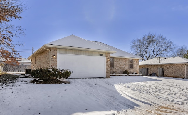 single story home featuring central air condition unit and a garage