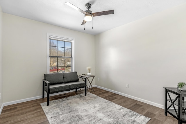 sitting room with dark hardwood / wood-style floors and ceiling fan