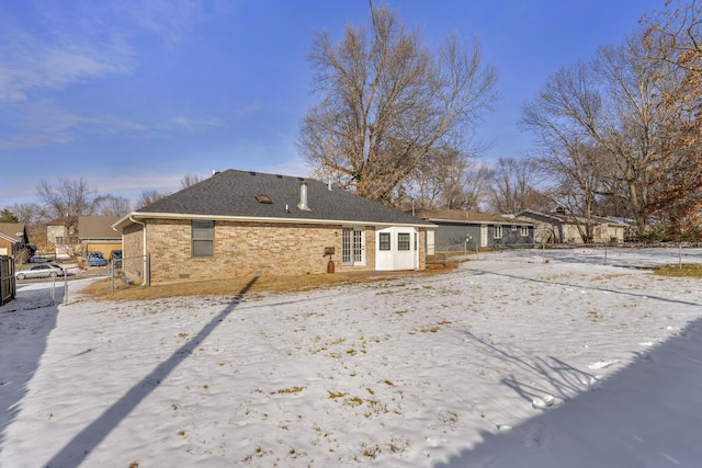 view of snow covered rear of property