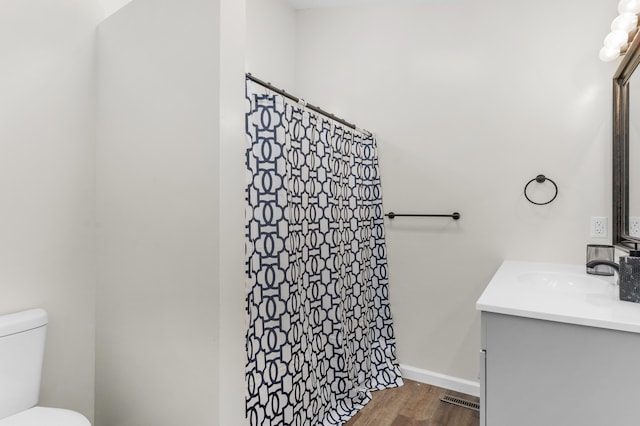 bathroom with vanity, hardwood / wood-style flooring, toilet, and walk in shower