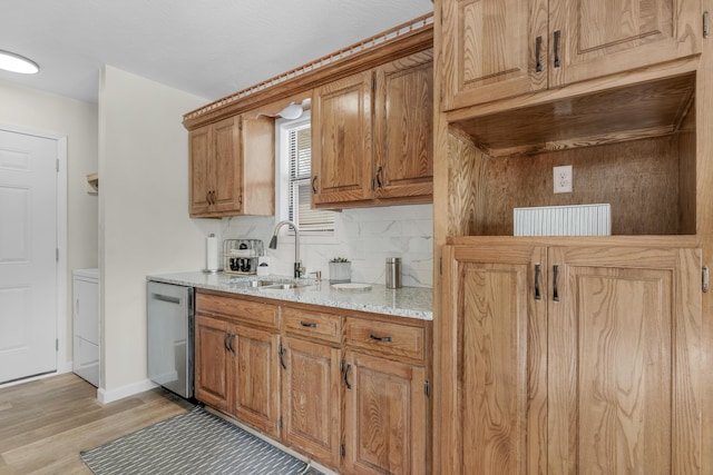 kitchen with backsplash, sink, stainless steel dishwasher, light stone countertops, and light wood-type flooring