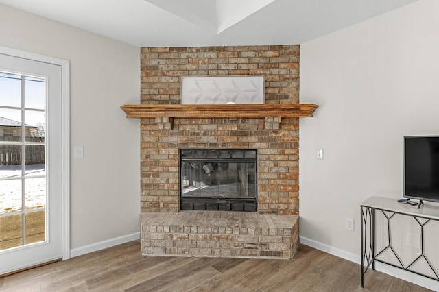 living room with hardwood / wood-style flooring and a brick fireplace