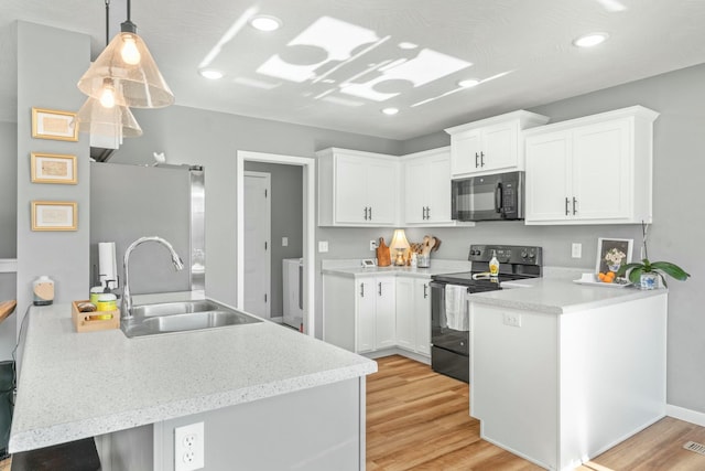 kitchen featuring sink, black appliances, kitchen peninsula, and white cabinets