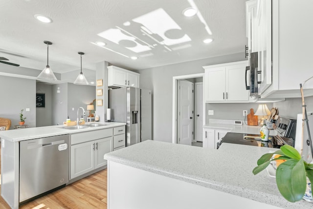 kitchen with sink, kitchen peninsula, white cabinets, and appliances with stainless steel finishes