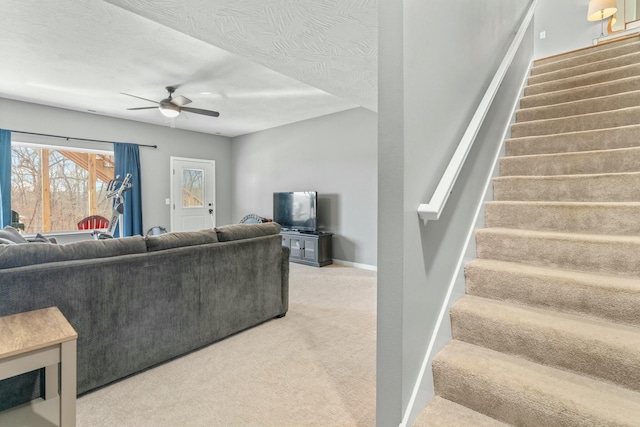 living room with ceiling fan, carpet, and a textured ceiling