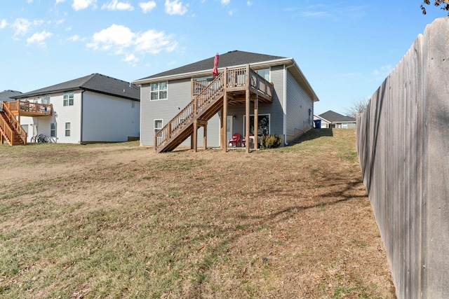 rear view of house featuring a deck and a lawn