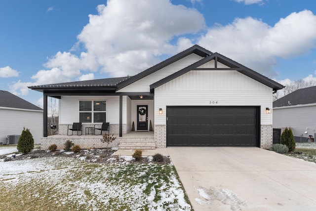 view of front of property featuring a porch, a garage, and cooling unit