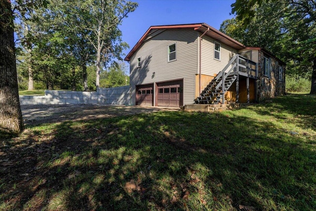 view of home's exterior with a yard, a deck, and a garage