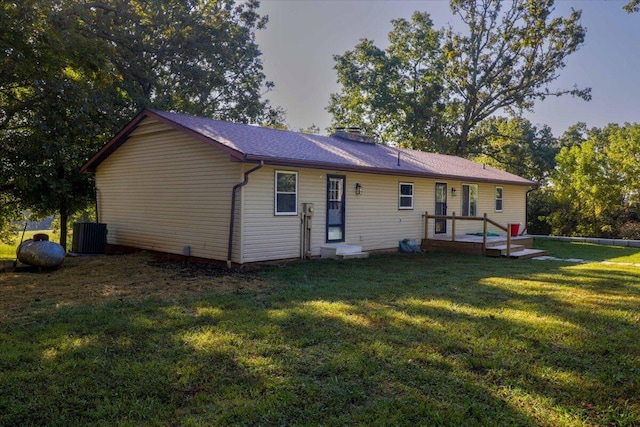 rear view of property featuring a lawn