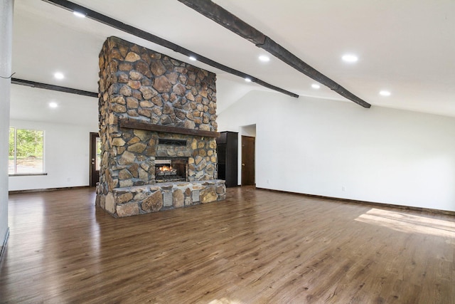 unfurnished living room with a stone fireplace, dark wood-type flooring, and vaulted ceiling with beams