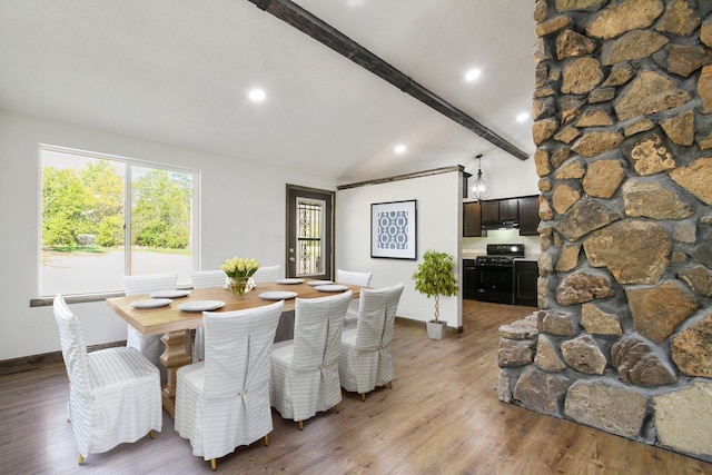 dining room featuring lofted ceiling with beams and hardwood / wood-style flooring