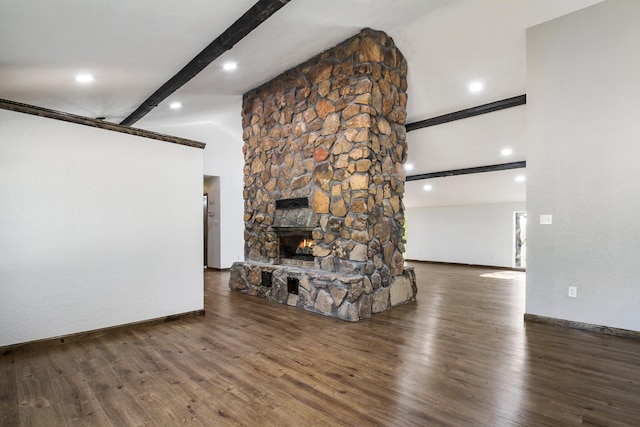 unfurnished living room with a stone fireplace, dark hardwood / wood-style flooring, and vaulted ceiling