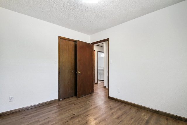 unfurnished room featuring a textured ceiling and dark wood-type flooring