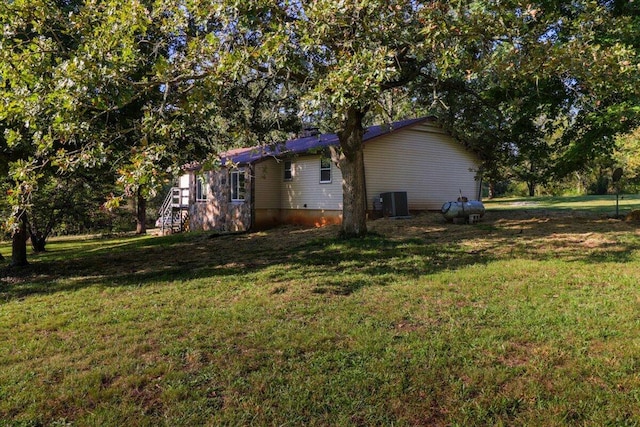 view of side of home featuring a lawn and cooling unit