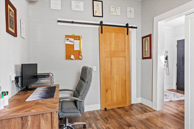 home office featuring a barn door and dark hardwood / wood-style floors