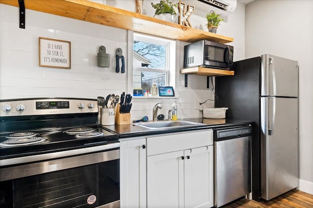 kitchen featuring white cabinets, sink, decorative backsplash, light wood-type flooring, and appliances with stainless steel finishes