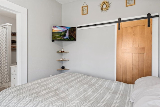 bedroom featuring a barn door and connected bathroom