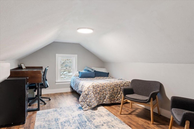 bedroom with wood-type flooring and lofted ceiling