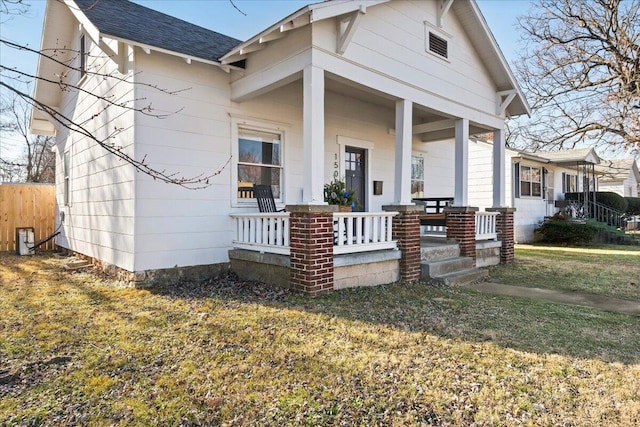 bungalow-style house featuring a front lawn and covered porch