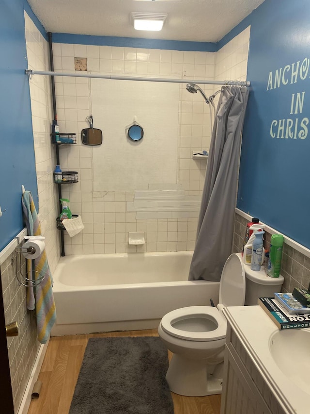 full bathroom featuring toilet, vanity, shower / bath combo with shower curtain, tile walls, and hardwood / wood-style flooring