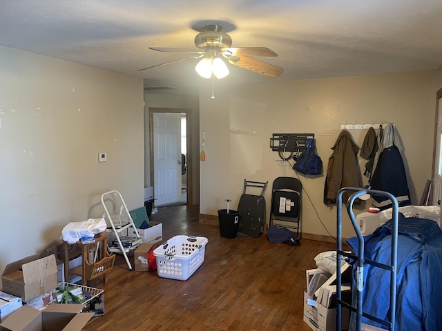 bedroom featuring ceiling fan, dark hardwood / wood-style flooring, and a textured ceiling